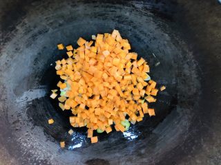 胡萝卜青椒蛋炒饭,起锅烧油，油热后先放葱花爆香，然后放入胡萝卜丁翻炒。