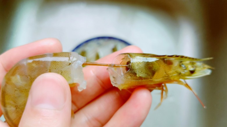 鲜美嫩滑的虾仁蒸蛋羹,蒸蛋的间隙来处理虾，轻轻拽着虾头去除虾线。再剥虾壳，在对虾背部轻轻划一下。