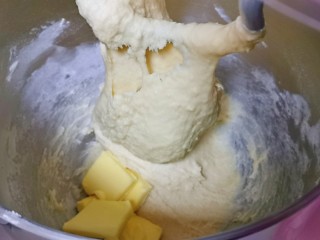 奶香软欧包,再加入室温软化的黄油，再次启动厨师机2-3档揉至不容易破的手套膜。