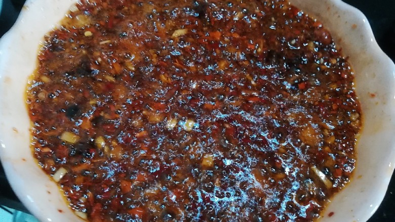桂花香菇牛肉油辣酱  下饭神器,将留下的一半鸡油分两次加热至开始冒烟，然后趁热倒入辣椒碗，翻拌均匀
