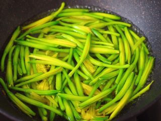 黄花菜炒肉片,把黄花菜摘洗干净后，锅中倒入适量的清水烧开后，把黄花菜进行焯水2分钟后。
