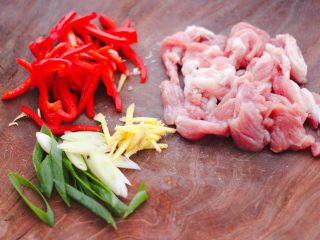 黄花菜炒肉片,把猪肉用刀切成薄片，红椒切丝，葱姜切丝备用。