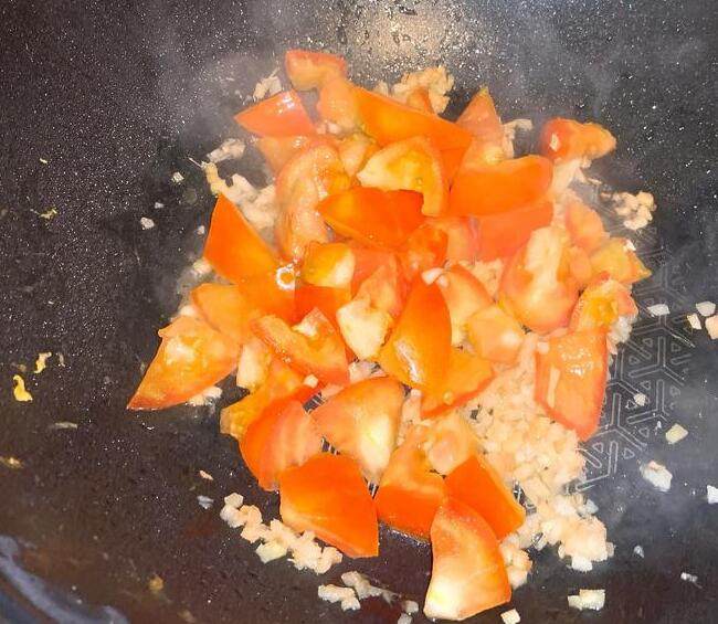 素麻婆豆腐,开中火热油锅，将姜末、蒜末爆出香味后，放入番茄块拌炒。