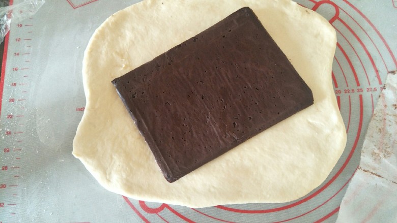 可可千层吐司🍞（牛奶巧克力夹心）,把面团擀成方形，包入巧克力片。捏好接缝处。