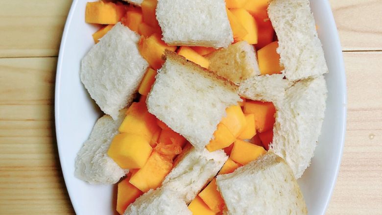 南瓜烤吐司布丁,将切片面包块和南瓜块放入烤盘中。