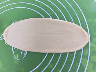 酥粒椰蓉面包,将剂子擀成椭圆形。