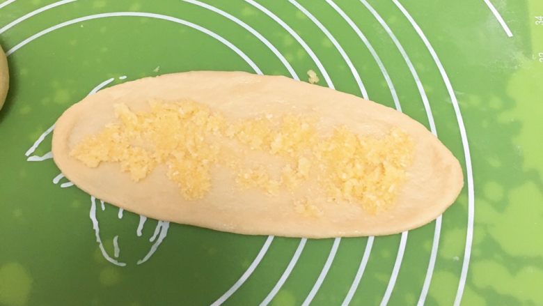 酥粒椰蓉面包,铺上椰蓉馅，顺势卷起来，中间开一刀。