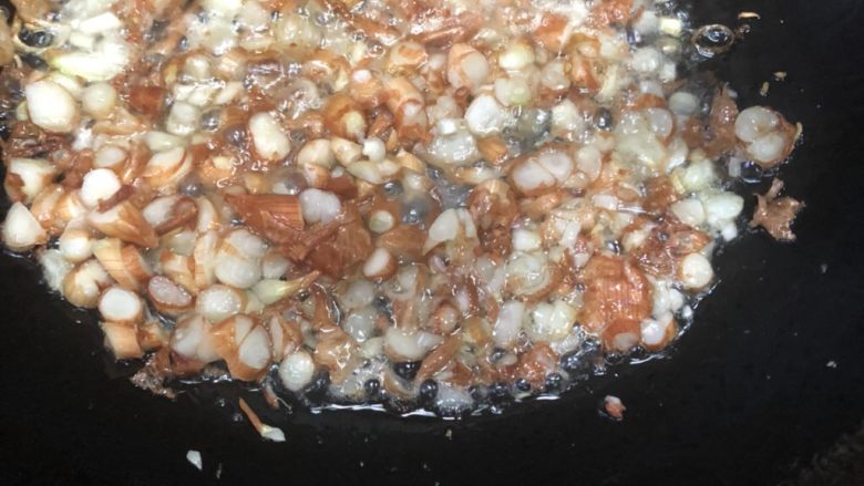 长豆饭（豇豆角饭）,肥肉煎好后拨到一边，放入切好的葱头，用锅铲轻轻画圈摩擦葱头，让它圈圈分离，煎香。