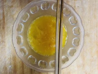 洋葱炒鸡蛋,碗中打入两枚鸡蛋，加入少量的食盐，用筷子搅拌均匀。