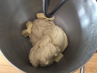 豆沙馅双色扭扭面包,加入黄油，继续揉面12分钟。
