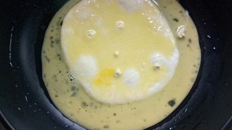 香蕉飞饼卷,将蛋液淋在飞饼坯上，摊平。