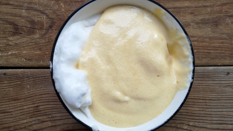 舒芙蕾——给你做舒芙蕾的人 一定很爱你,将翻拌好的蛋黄糊加入到剩下的2/3蛋白霜中。