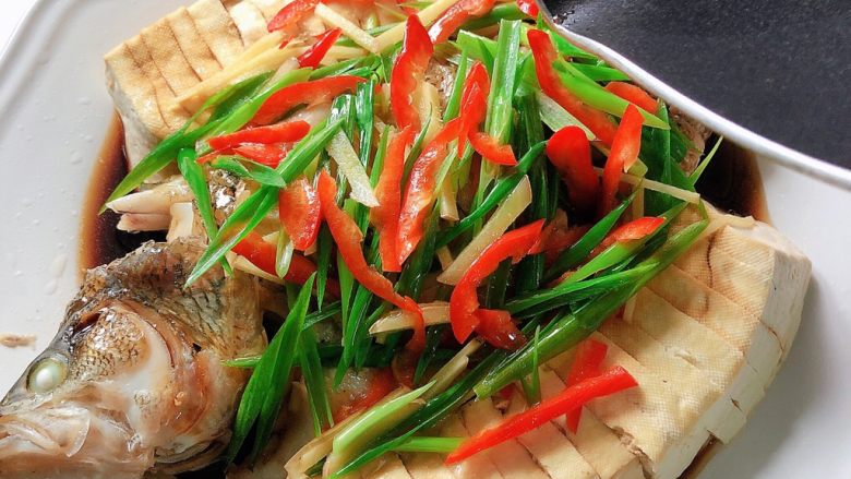 油泼鱼,将热油浇在鱼和蔬菜身上，葱姜发出浓烈的香味。
