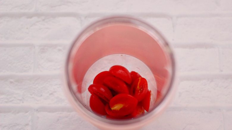 火龙果小番茄蜂蜜果汁,先把果汁杯冲洗干净后，把切片的小番茄放入杯中。