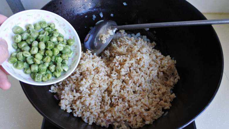 蔬菜培根炒饭,倒入米饭，放入豌豆