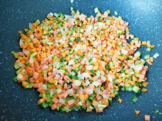 炒杂粮饭,下入胡萝卜、火腿肠和黄瓜丁翻炒均匀。