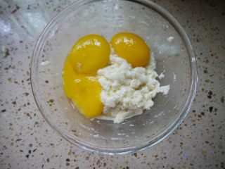 肉松小贝,把蛋黄倒入面糊中，用打蛋器搅拌均匀，搅拌好的面糊顺滑、细腻无颗粒。
