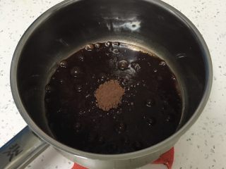 可可毛坯蛋糕,关火后倒入可可粉，用刮刀拌匀后加入牛奶再拌匀，放旁边冷却。