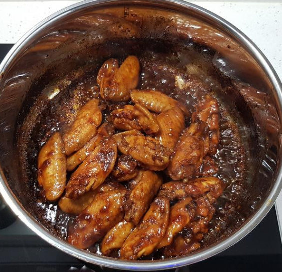 蒜香蜂蜜啤酒鸡翅,打开锅盖，将鸡翅拌炒翻面，继续煮至酱汁收乾，即可关火盛盘。