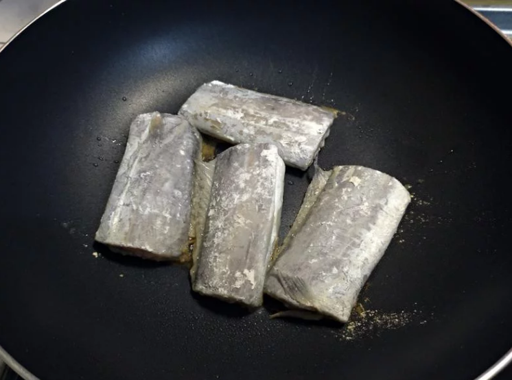 香柠乾煎白带鱼,先热锅完成再倒点油， 依序放下沾好煎鱼粉的白带鱼，切记不要马上急著翻面。