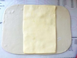 手撕金砖吐司,裁掉包裹黄油的保鲜袋，将黄油片摆放在面片中间