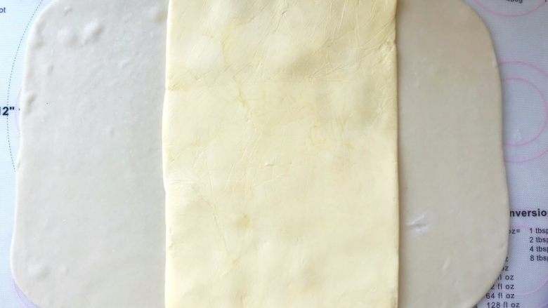 手撕金砖吐司,裁掉包裹黄油的保鲜袋，将黄油片摆放在面片中间