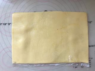 手撕金砖吐司,黄油软化后，用手先将裱花袋的两个角捏满，之后对折裱花袋，将黄油擀成厚度均匀的黄油片，同样放冰箱冷冻7、8分钟
