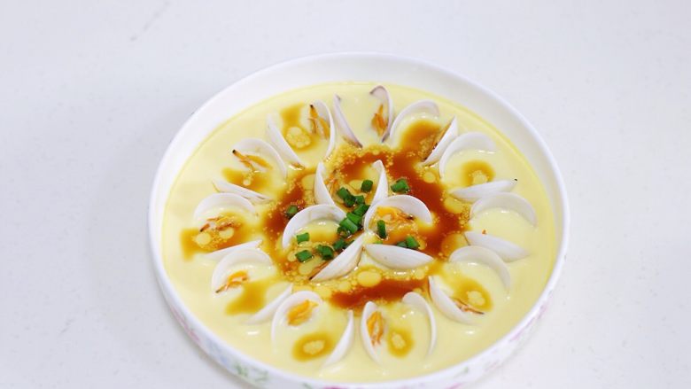 蛤蜊蒸蛋,往蒸好的蛤蜊蛋羹中淋入调料汁，撒上葱花。