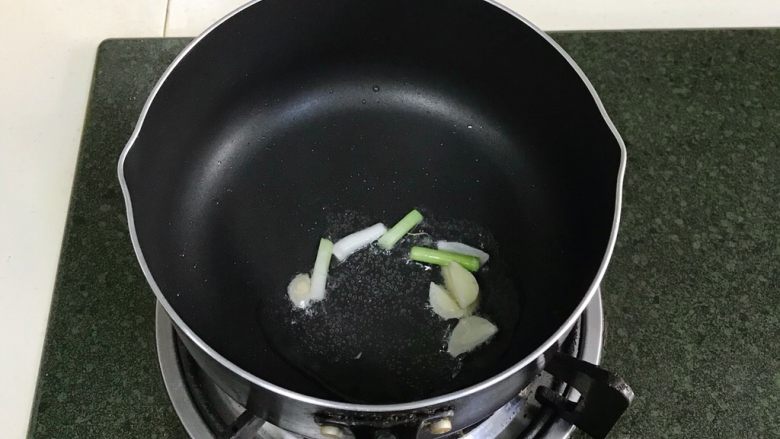 蛤蜊蒸蛋,锅中倒入食用油，小火炒香蒜片和小葱段。