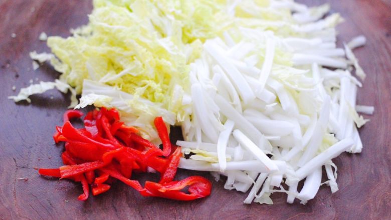 天鹅蛋白菜海鲜小炒,把大白菜用刀切成丝，红椒也切成丝。