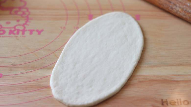 无油无蛋酸奶面包,取一个面团，擀开长的椭圆形。边缘的气泡也排掉。
