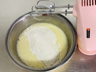 蓝莓爆浆玛芬,加入过筛的面粉，先用打蛋器轻轻搅拌干粉融入液体后，再打开打蛋器进行搅打。