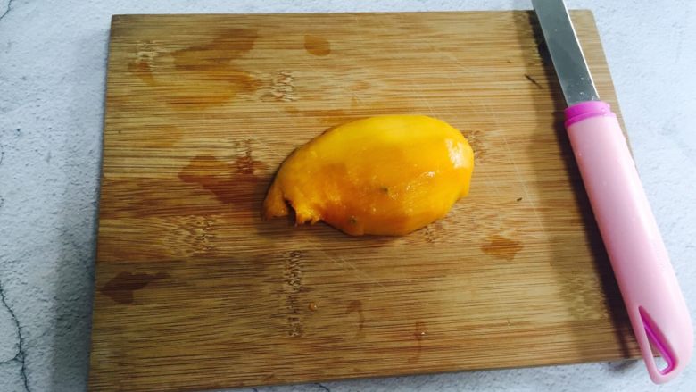 芒果香蕉奶昔,将另外一半芒果削皮