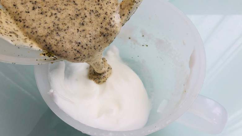 宝宝零食：黑芝麻饼干,把蛋黄糊倒入到剩余最后的蛋白，换盆操作，继续混合。这样换个容器搅拌的目的也是为了混合均匀。