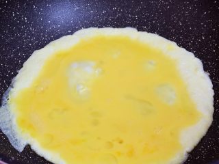 青椒火腿肠炒鸡蛋,锅中倒入适量的食用油烧热，倒入鸡蛋液