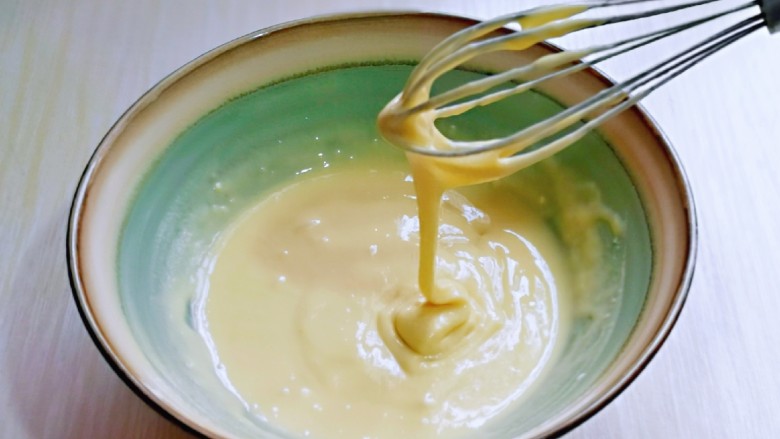 无油低脂～奶香松饼,翻拌均匀，且无干粉，提起打蛋器面糊自由流动状态即可，放旁边备用。