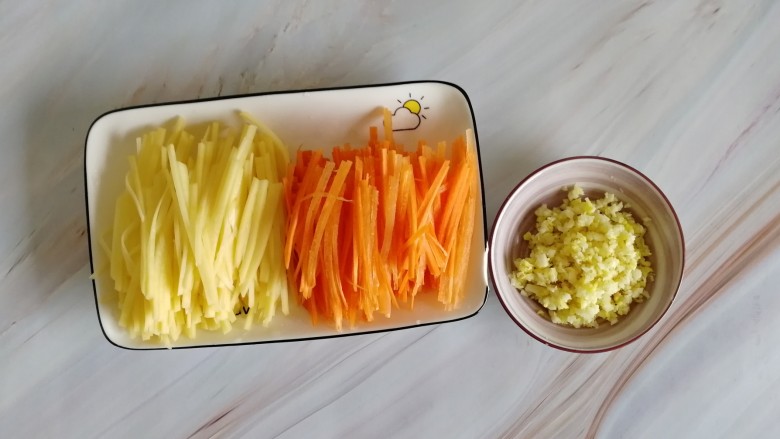 胡萝卜浓汤意面,把切好的胡萝卜丝、土豆丝、生姜大蒜末装盘，备用