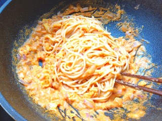 胡萝卜浓汤意面,下入意面用筷子搅拌均匀，用筷子卷好意面放入盘子。