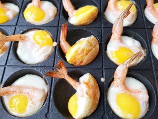 虾扯蛋,待表面蛋液凝固，用叉子推起香脆的面糊加上鹌鹑蛋和鲜虾做出来的小半球，看到底部金黄焦脆。