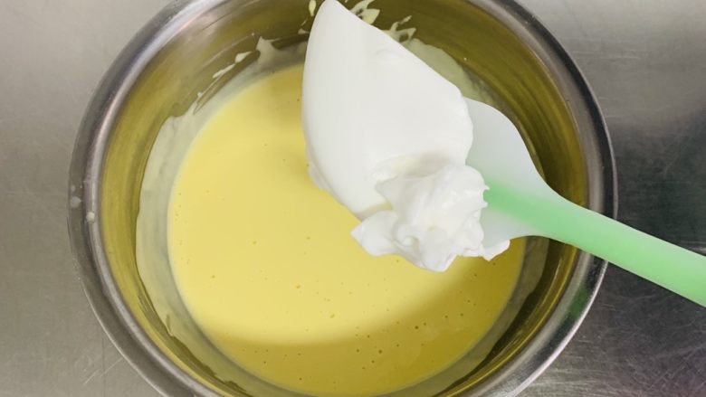 粘米糕,取一刮刀的蛋白与蛋黄液搅拌均匀。