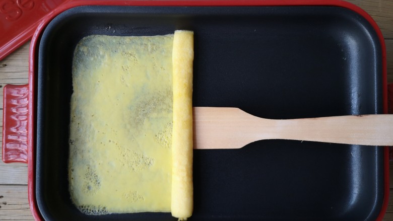 酷夏里的小清新——青瓜厚蛋烧,待蛋液稍凝固利用硅胶刮刀或木铲折叠蛋皮从右端卷起。
