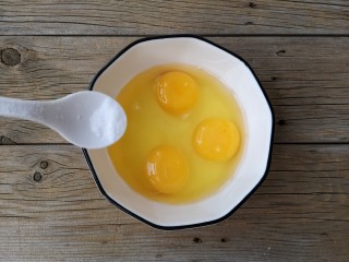 酷夏里的小清新——青瓜厚蛋烧,将鸡蛋磕入碗中，根据个人口味在鸡蛋中加适量的盐或白糖。