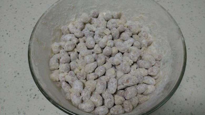 鱼皮花生,晃动碗，使每一个花生豆均匀粘上面粉。