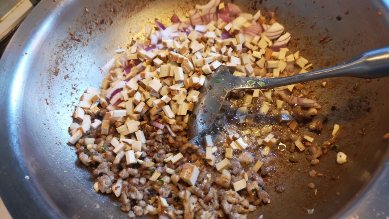 川味哨子面,加入生抽，放入豆腐干和洋葱，炒至金黄。