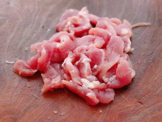 双椒肉片炒花菜,猪肉洗净后，用刀切成薄片。