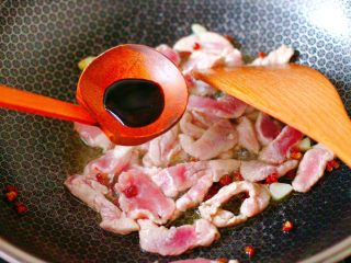 双椒肉片炒花菜,大火翻炒至猪肉变色的时候，放入生抽调味调色。