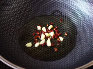 双椒肉片炒花菜,另起锅烧热后，倒入花生油烧至六成热时，小火慢慢炸香花椒后，再爆香蒜片。