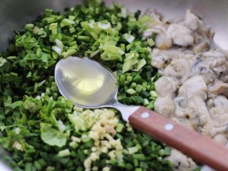 牡蛎韭菜粉嫩饺子,先加入花生油把韭菜搅拌均匀，这样做的目的是韭菜不会出水。