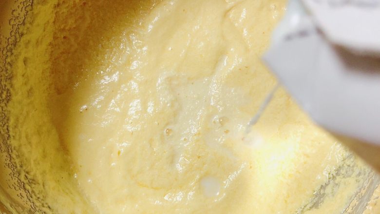 迷迭香玛芬蛋糕（制作耗时最短）,打发好的黄油鸡蛋液中，加入80ml牛奶，用打蛋器轻搅均匀。
