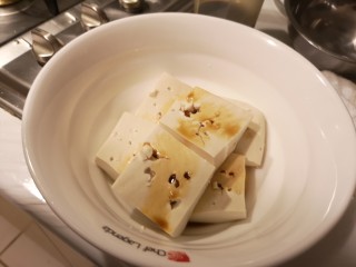 麻辣肉片豆花,装盘，用筷子在豆腐上戳些洞，倒入少许生抽。